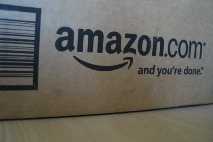 Close-up of an Amazon.com shipping box showing the company’s logo and slogan.