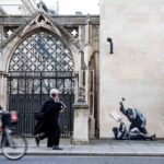 Banksy street art mural on the Royal Courts of Justice in London depicting a judge in a wig and gown striking a bloodied protester with a gavel.