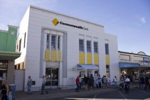 A modern Commonwealth Bank branch with red CommBank logo on its exterior, located on a sunny day in Leeton, NSW.