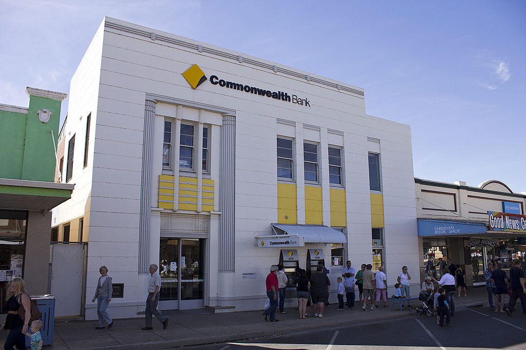 A modern Commonwealth Bank branch with red CommBank logo on its exterior, located on a sunny day in Leeton, NSW.