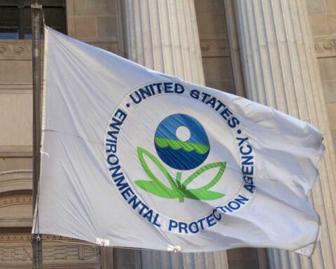 EPA flag with the agency's logo flying in front of a government building with classical columns.