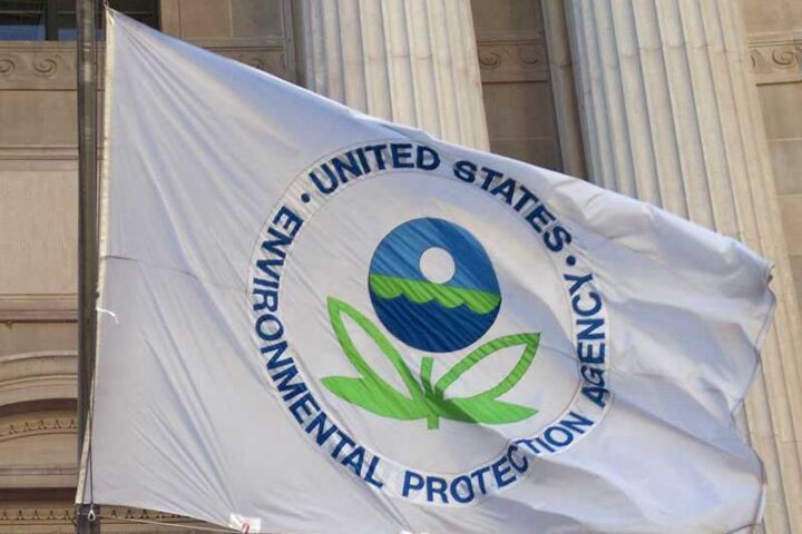 EPA flag with the agency's logo flying in front of a government building with classical columns.