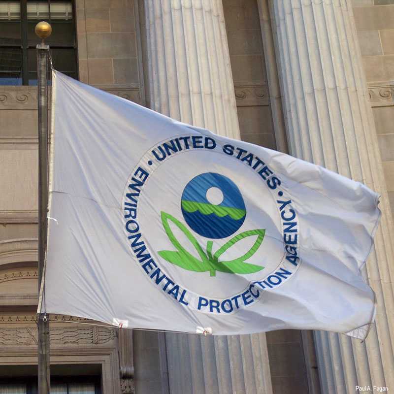 EPA flag with the agency's logo flying in front of a government building with classical columns.