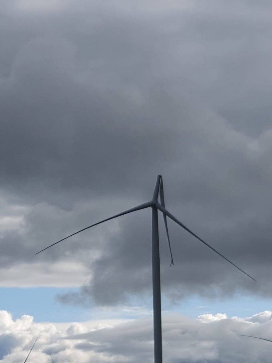Broken wind turbine blade at Flyers Creek Wind Farm in NSW against a grey cloudy sky.