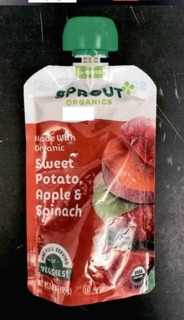 Sprout Organics Sweet Potato Apple and Spinach baby food pouch showing front packaging with green cap and colorful vegetable imagery on dark surface