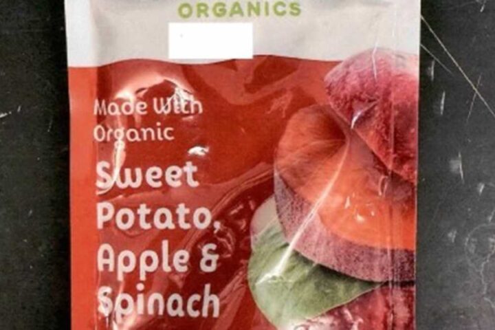 Sprout Organics Sweet Potato Apple and Spinach baby food pouch showing front packaging with green cap and colorful vegetable imagery on dark surface