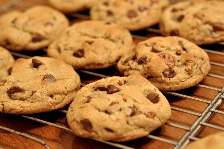 Freshly baked chocolate chip cookies cooling on a wire rack, showing their golden brown color and chocolate chips