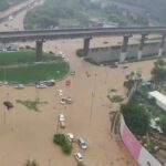 Flooded Gurgaon underpass with cars stranded in brown rainwater after heavy monsoon rainfall, highlighting poor drainage and urban flooding issues.