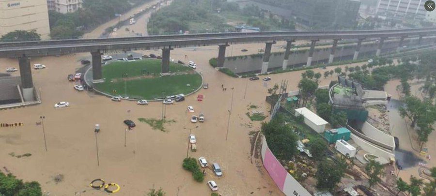 Flooded Gurgaon underpass with cars stranded in brown rainwater after heavy monsoon rainfall, highlighting poor drainage and urban flooding issues.