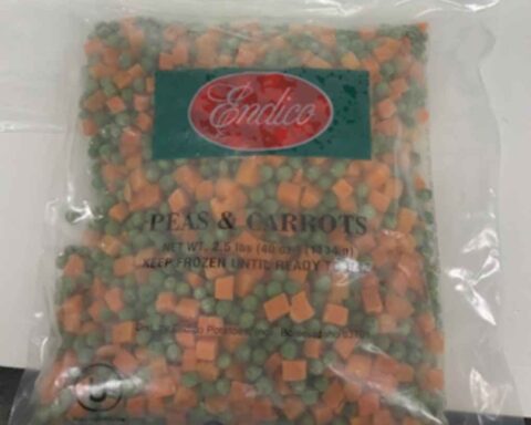 Clear plastic bag of Endico frozen peas and carrots with green label showing the brand name on red background