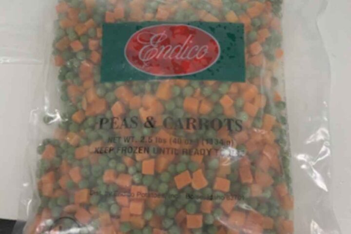 Clear plastic bag of Endico frozen peas and carrots with green label showing the brand name on red background
