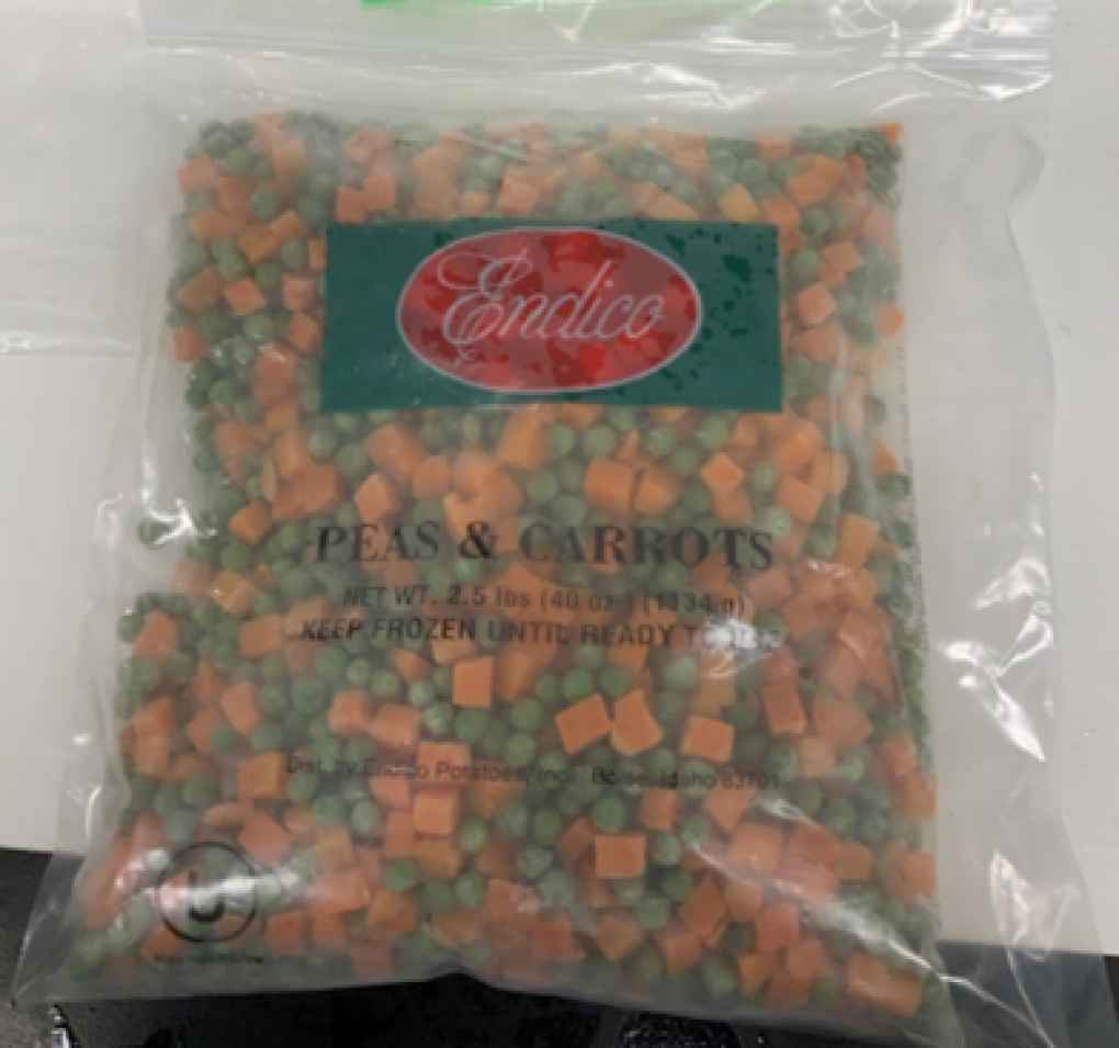 Clear plastic bag of Endico frozen peas and carrots with green label showing the brand name on red background