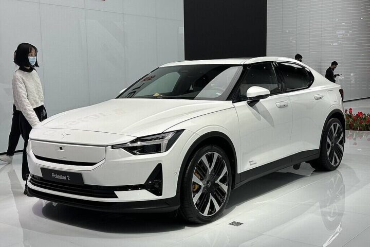 White Polestar 2 electric vehicle displayed at auto show with minimalist Scandinavian design features