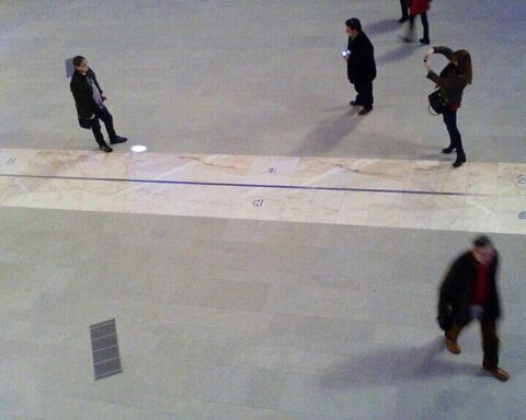 Security camera footage showing several people walking through an indoor corridor, likely seeking relief from extreme outdoor temperatures.