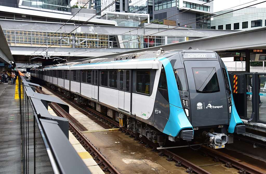 A modern, fully automated Sydney Metro train stopped at the platform of Chatswood Station, a key junction in the network's power supply infrastructure.