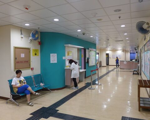 Representative Image. Interior lobby of Sai Wan Ho Sports Centre showing a reception desk with staff, waiting area with blue walls, and a person sitting on chairs in the waiting area.