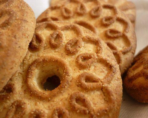 Representative Image. Traditional round biscuits with decorative patterns and a hole in the center, arranged on a light surface.