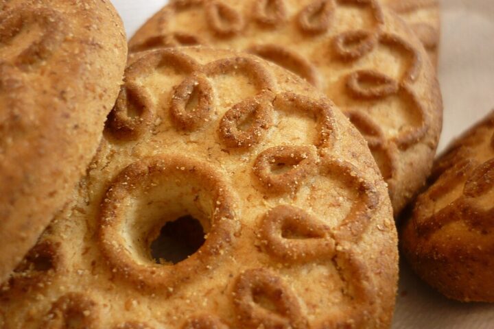 Representative Image. Traditional round biscuits with decorative patterns and a hole in the center, arranged on a light surface.