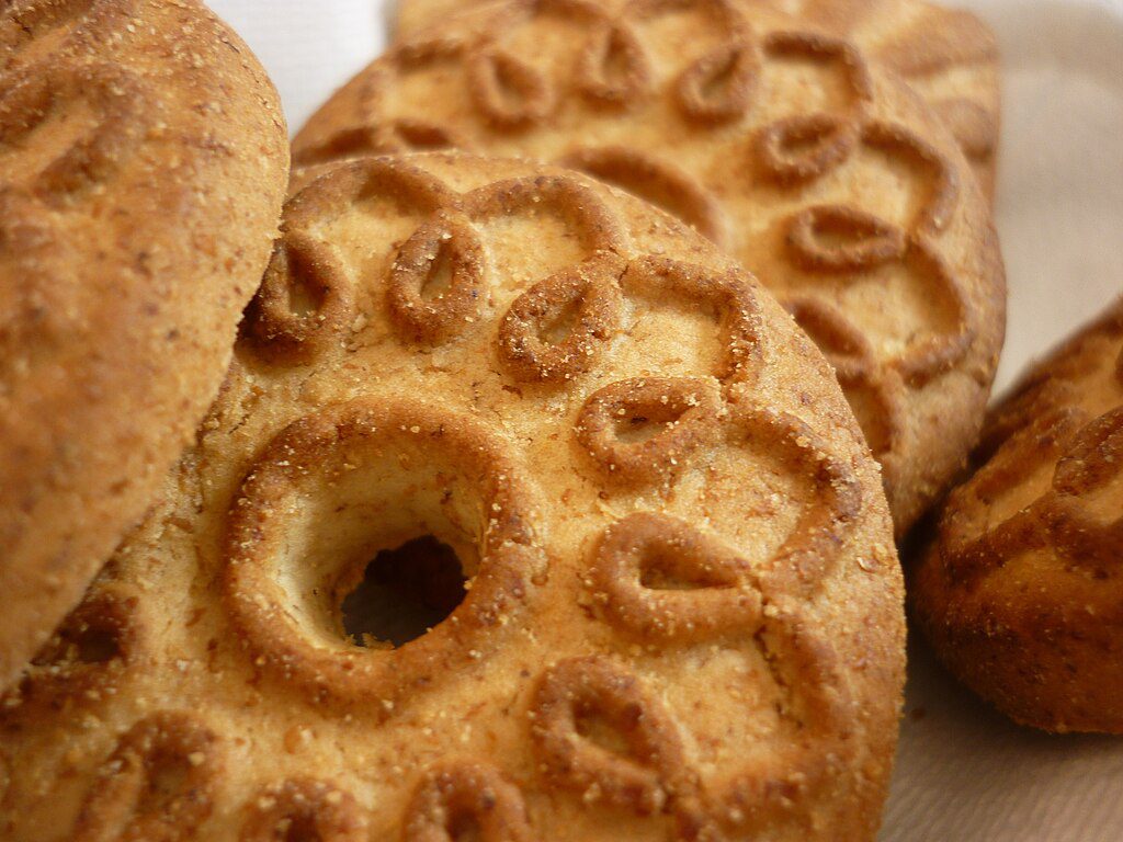 Representative Image. Traditional round biscuits with decorative patterns and a hole in the center, arranged on a light surface.
