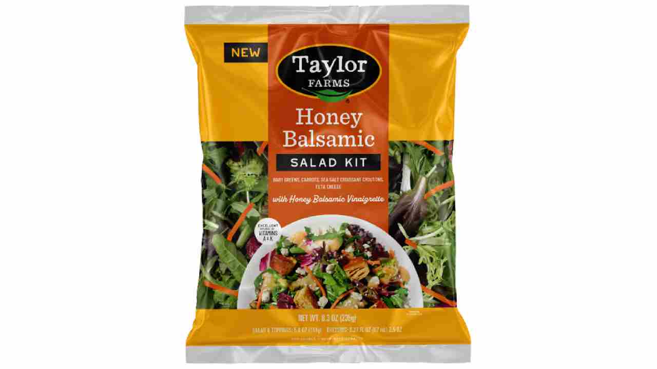Taylor Farms Honey Balsamic Salad Kit in yellow and orange packaging showing baby greens, carrots, and feta cheese with honey balsamic vinaigrette dressing that has been recalled due to undeclared allergens.