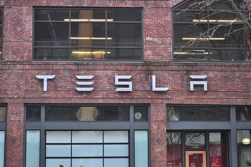 Tesla storefront on brick building at 435 Westlake North in Seattle, Washington, showing the company logo and large glass windows of the showroom.