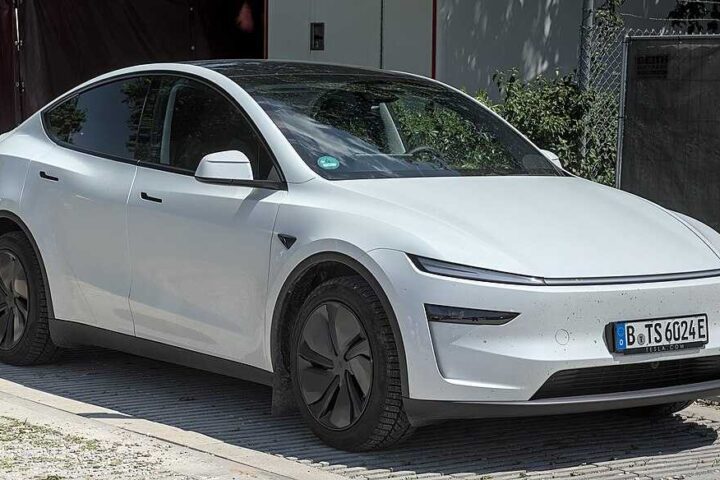 A white Tesla Model Y electric SUV parked outdoors at the MYLE Festival 2023, showing its distinctive aerodynamic profile and minimalist design.