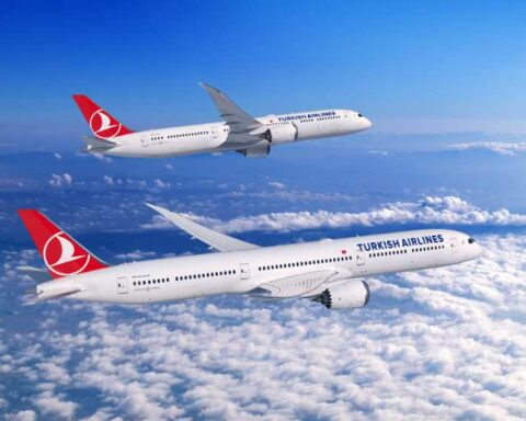 A Boeing 787 Dreamliner in Turkish Airlines livery flying above clouds, showcasing the aircraft's distinctive swept wings and advanced aerodynamic design.