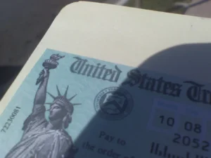 Close-up of a United States Treasury Social Security check featuring the Statue of Liberty and Treasury seal.