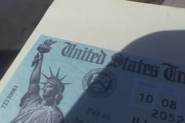 Close-up of a United States Treasury Social Security check featuring the Statue of Liberty and Treasury seal.