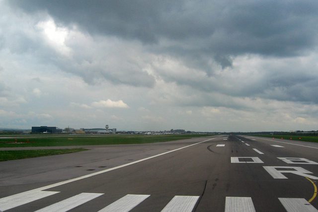 View of Runway 08-R at London Gatwick Airport showing the main runway with cloudy sky above.