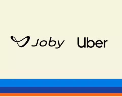 Joby and Uber logos displayed side by side on a cream-colored background with blue and orange horizontal stripes at the bottom of the image.