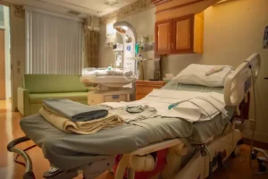Empty hospital room with a neatly made bed, medical monitoring equipment, and basic furnishings in a VA medical facility.