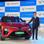 VinFast VF7 electric SUV showcased at India launch event alongside company executive, highlighting entry price of ₹20.89 lakh.