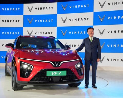 VinFast VF7 electric SUV showcased at India launch event alongside company executive, highlighting entry price of ₹20.89 lakh.