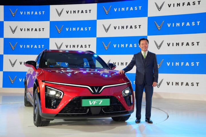 VinFast VF7 electric SUV showcased at India launch event alongside company executive, highlighting entry price of ₹20.89 lakh.