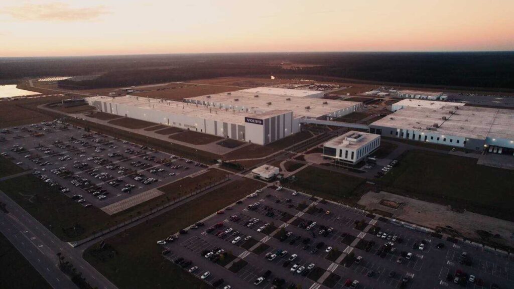 Aerial view of Volvo's Ridgeville manufacturing facility in South Carolina, showing the expansive 2.3 million square foot plant with surrounding parking lots at sunset.