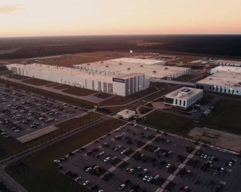 Aerial view of Volvo's Ridgeville manufacturing facility in South Carolina, showing the expansive 2.3 million square foot plant with surrounding parking lots at sunset.