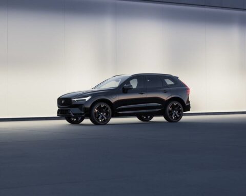 Black Volvo XC60 Black Edition SUV displayed against a minimalist light-colored backdrop, showcasing its sleek profile and distinctive black wheels.
