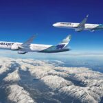 Two WestJet aircraft - a Boeing 737 in the foreground and a Boeing 787 Dreamliner in the background - flying over snow-capped mountains of the Canadian Rockies against a clear blue sky.