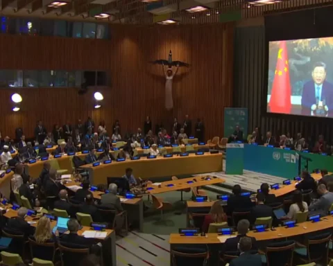 Chinese President Xi Jinping delivering a video address on screen at the United Nations Climate Summit with delegates seated in the General Assembly Hall watching.