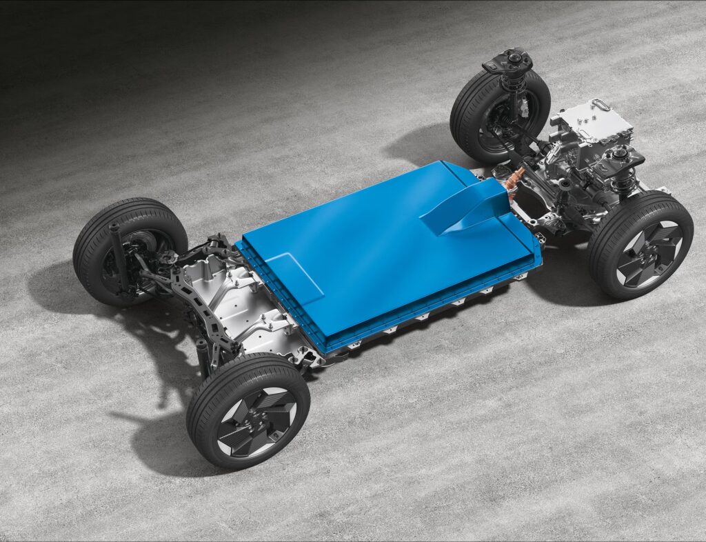 Exposed view of Maruti e VITARA's HEARTECT-e electric platform showing blue battery pack integrated into the chassis with wheels and drivetrain components visible.