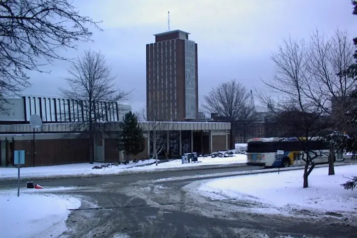 Bartle Library Tower photographed from below, showing its tall concrete structure against a cloudy sky.
