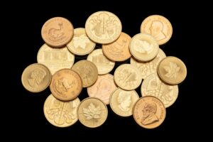 Close-up of assorted gold coins on a black surface, suitable for finance and currency themes