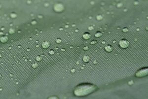 Water droplets on a green fabric surface.