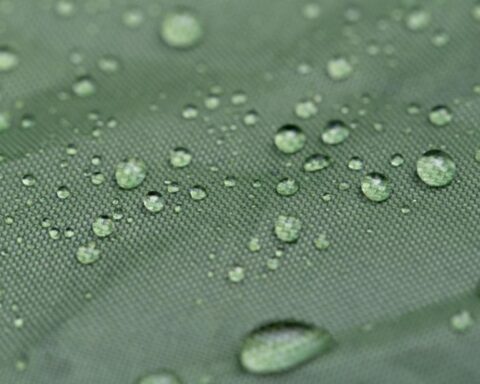 Water droplets on a green fabric surface.
