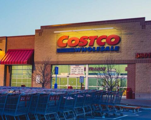 Exterior of a Costco Wholesale warehouse with customers and parked cars in front