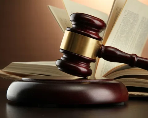 Wooden judge’s gavel on table, close-up, neutral background.