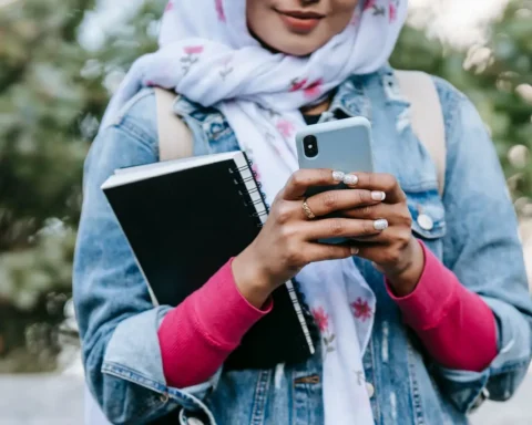 Close-up of a Muslim woman's hands holding a smartphone displaying no connection, symbolizing Afghanistan's internet shutdown.