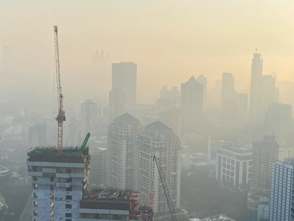 Massive dust cloud covering Mumbai skyline during evening hours as a result of construction activity and changing wind patterns.