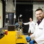Edward Attenborough and Dr Leonie van 't Hag working in a laboratory at Monash University with scientific equipment used for creating bioplastics from food waste sugars.